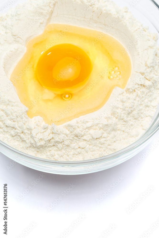 Flour with egg in glass bowl Flour with egg in glass bowl