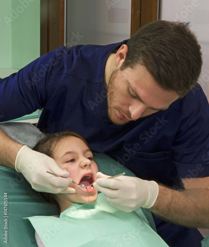 Dentista examinando los dientes de una ni  a.  ni  o en el dentista.