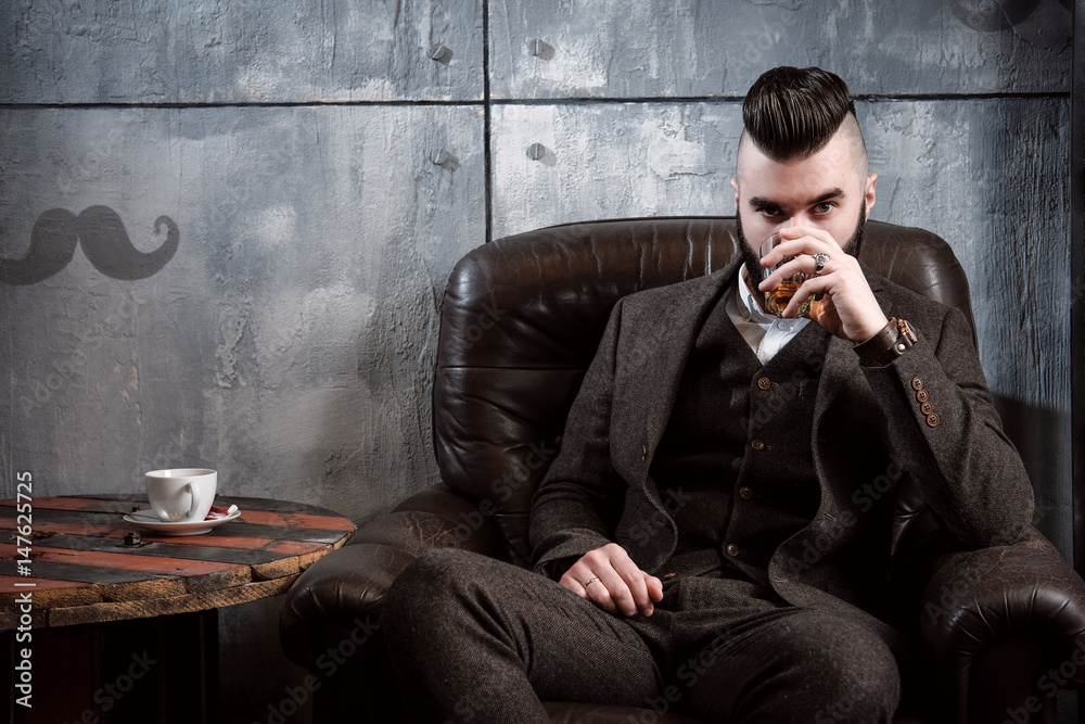 Brutal bearded man with beard posing, drinking whiskey Brutal bearded man with beard posing, drinking whiskey