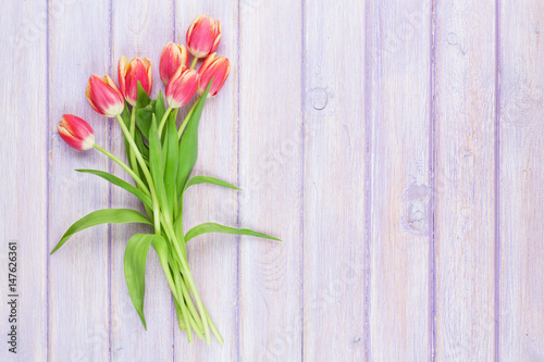 Fototapeta Naklejka Na Ścianę i Meble -  Red tulips over purple wooden table