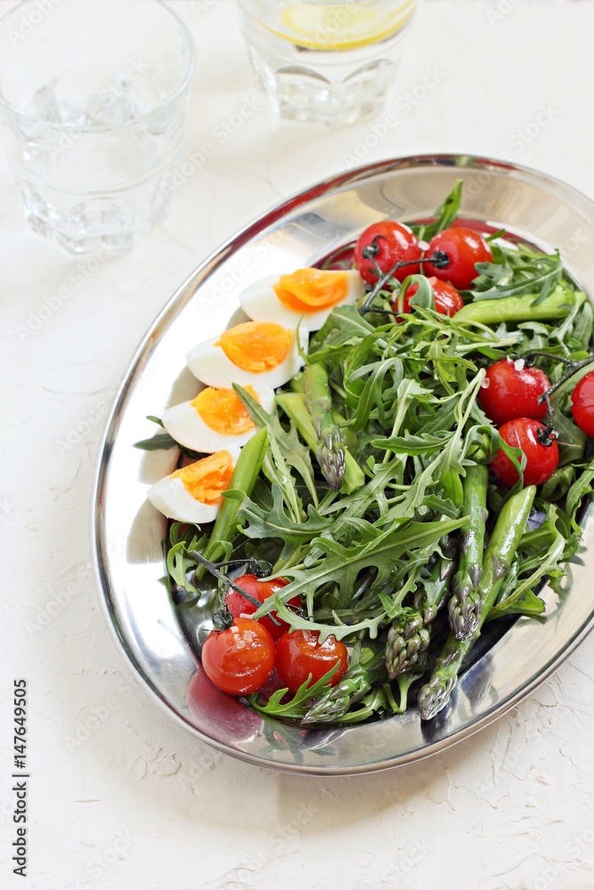 Asparagus salad with arugula, cherry tomatoes and eggs. Overhead view.
Asparagus salad with arugula, cherry tomatoes and eggs. Overhead view.