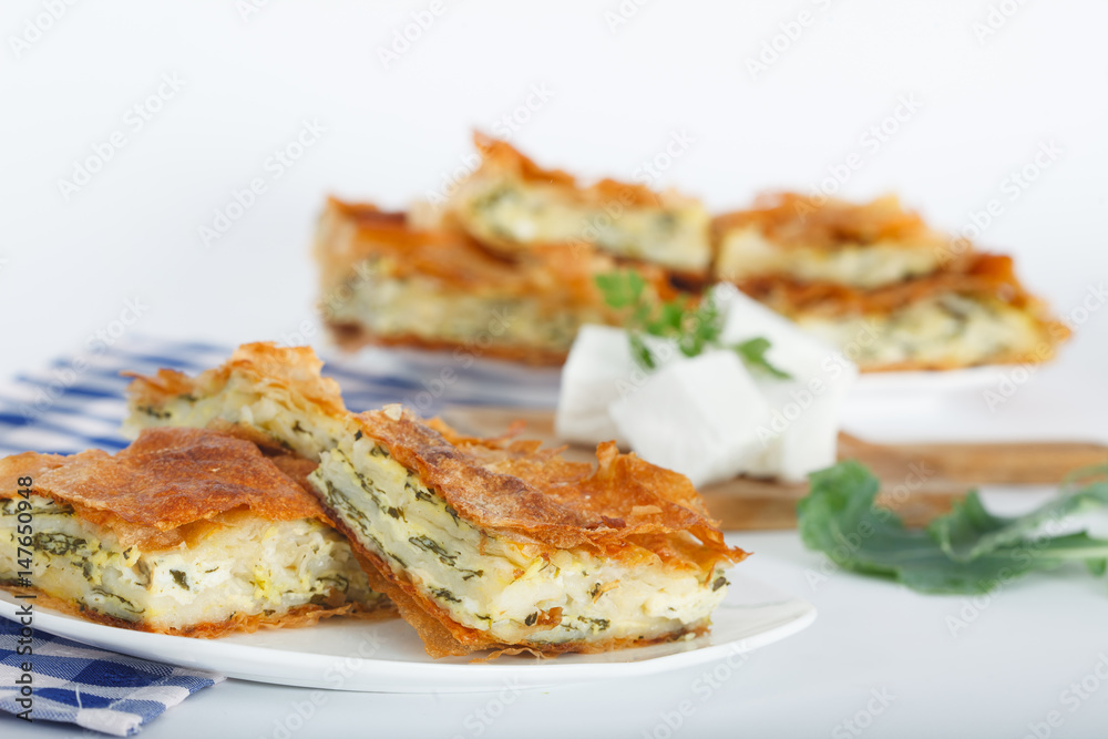 Delicious pie with spinach and feta cheese, traditional Greek, Serbian or Bulgarian cuisine. Delicious pie with spinach and feta cheese, traditional Greek, Serbian or Bulgarian cuisine.