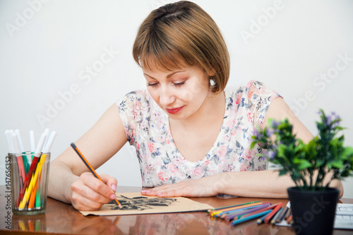 Young woman drawing at the desk