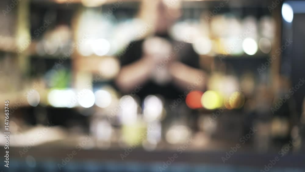 Close up of bartender Blurred shot of an unrecognizable bartender wiping glasses, mugs and a shaker with a rug. Locked down real time medium shot Close up of bartender Blurred shot of an unrecognizable bartender wiping glasses, mugs and a shaker with a rug. Locked down real time medium shot