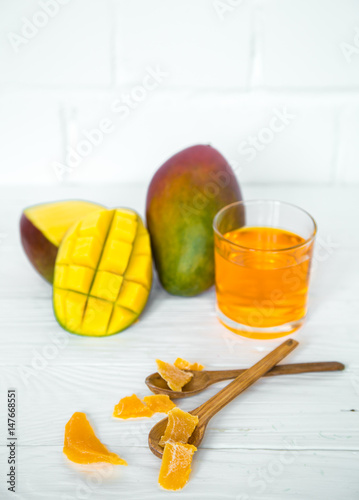Mango on a white wooden background with juice photo