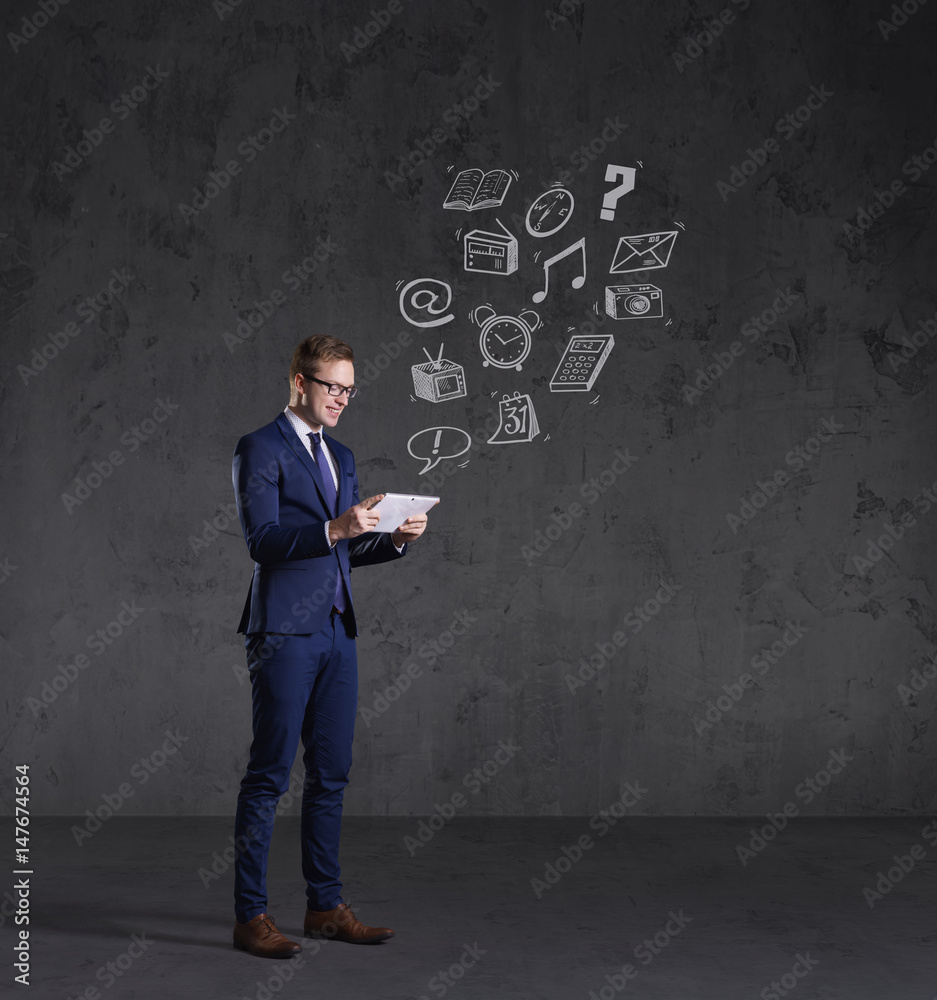 Businessman with a tablet gadget. Black background with copyspace. Business and office technology concept. Businessman with a tablet gadget. Black background with copyspace. Business and office technology concept.
