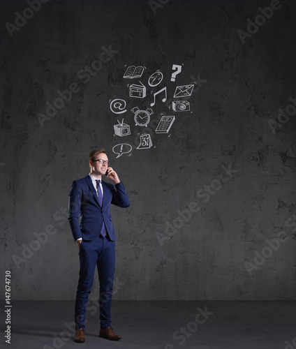 Businessman checking his smartphone on a dark dramatic background. Business, office, idea concept.