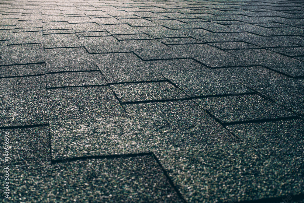 Obraz premium Side view of soft roof tiled greenish grainy texture on the top of summer house illuminated by warm sun