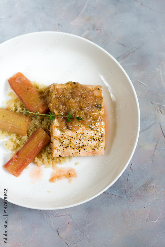 Grilled salmon with quinoa and rhubarb sauce. Gray background, white plate. Isolated. Grilled salmon with quinoa and rhubarb sauce. Gray background, white plate. Isolated.