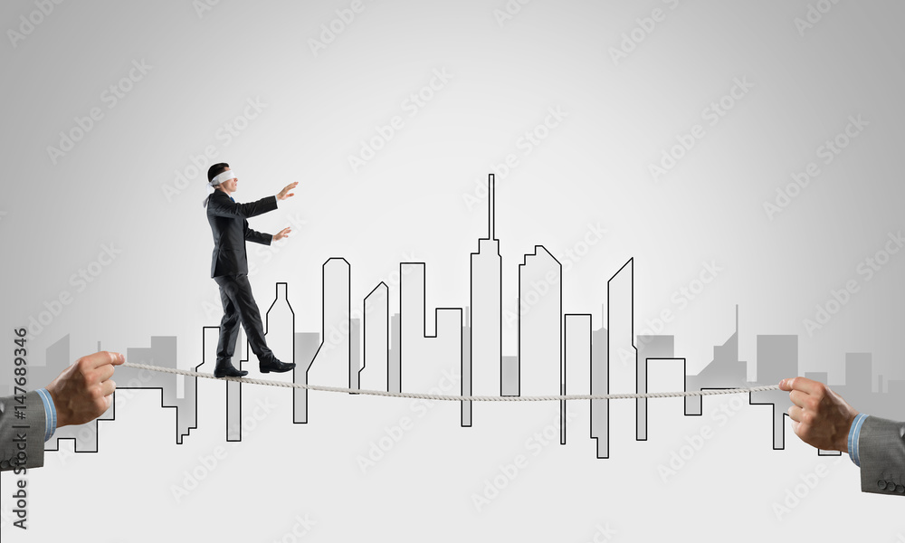 Business concept of risk support and assistance with man balancing on rope Business concept of risk support and assistance with man balancing on rope