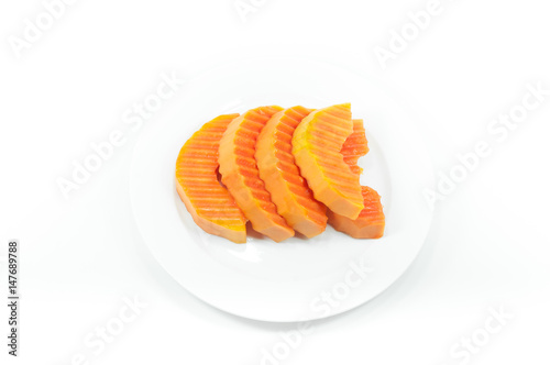 Ripe papaya fruit sliced on a white dish on white background