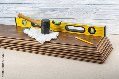 Carpentry concept.Different tools and gloves on the new laminate flooring.Copy space for text.
