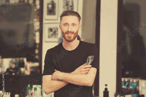 Young bearded barber at wor...