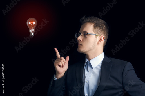 A man in a business suit on a black background indicates a stuck light bulb. "What if?" © drouk