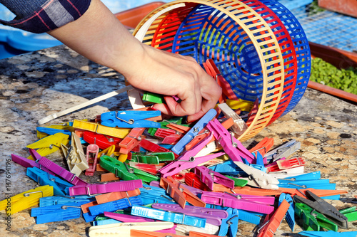 Clothespins. The hand takes the colorful plastic clothespins  stand on the table in the garden. Cloth clothespins.