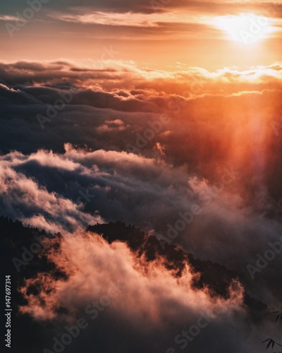Sun rising through foggy mountain texture