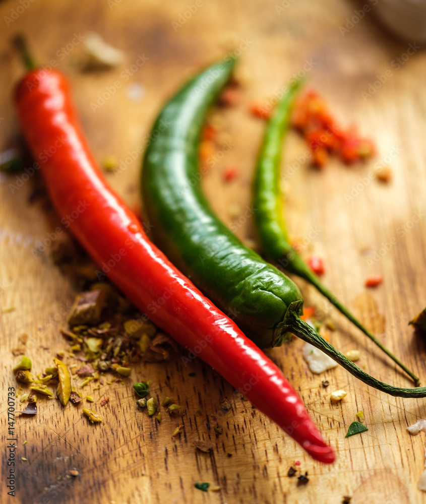 Close Up of Red and green chilli peppers on wooden cutting board. Close Up of Red and green chilli peppers on wooden cutting board.