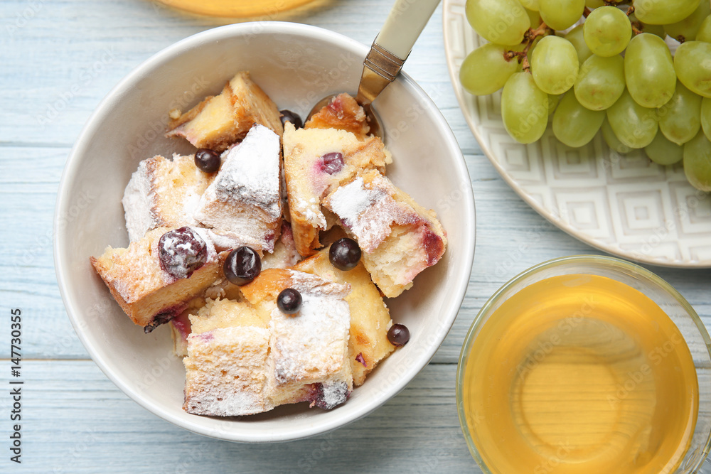 Delicious bread pudding with fruits and tea on wooden table Delicious bread pudding with fruits and tea on wooden table