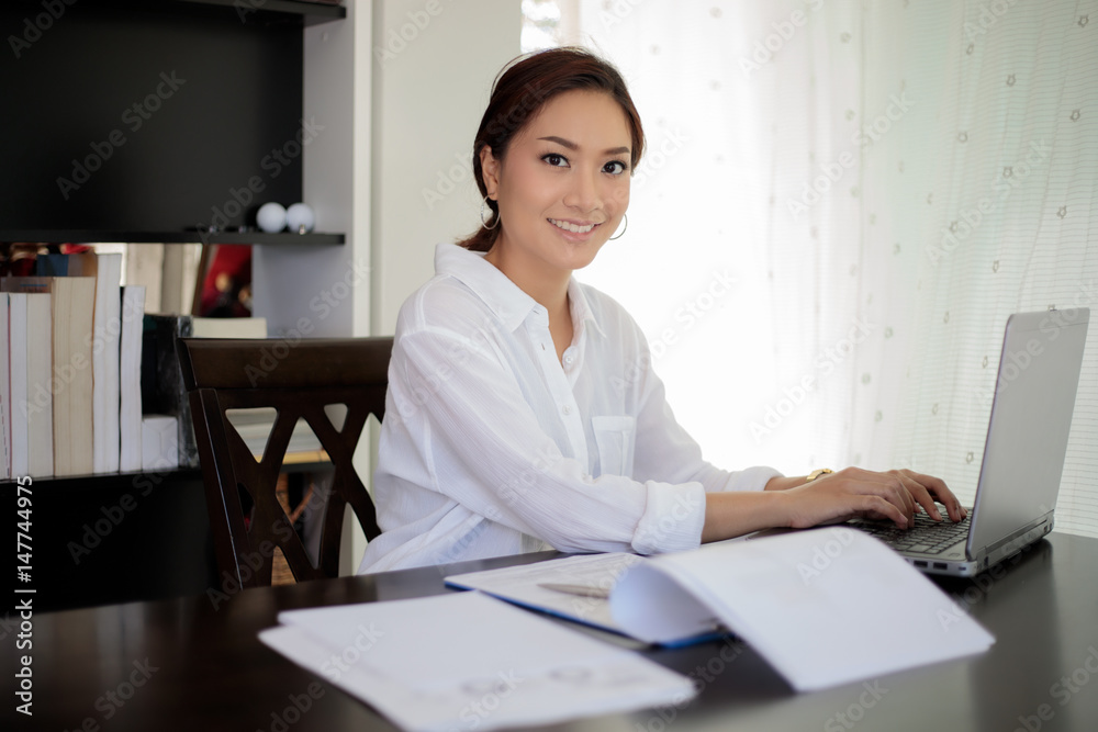 Asian business women using notebook and smiling happy for working Asian business women using notebook and smiling happy for working