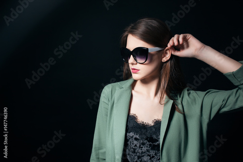 fashion business lady in sunglasses posing in studio;