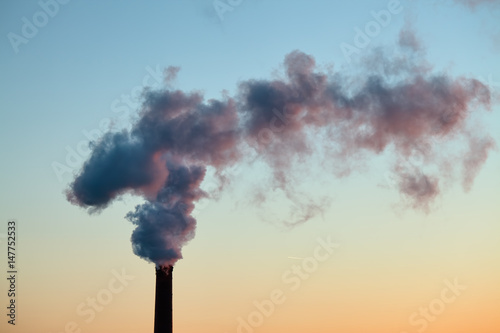 Smoke from the brick chimney of the plant in the early morning. The smoke from the pipe cogeneration plant. Ambient air pollution industrial emissions