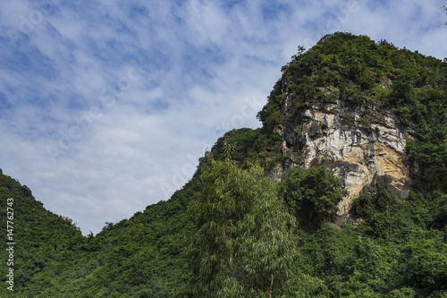 Green mountain with sandstone rock face, Ninh Binh, Vietnam