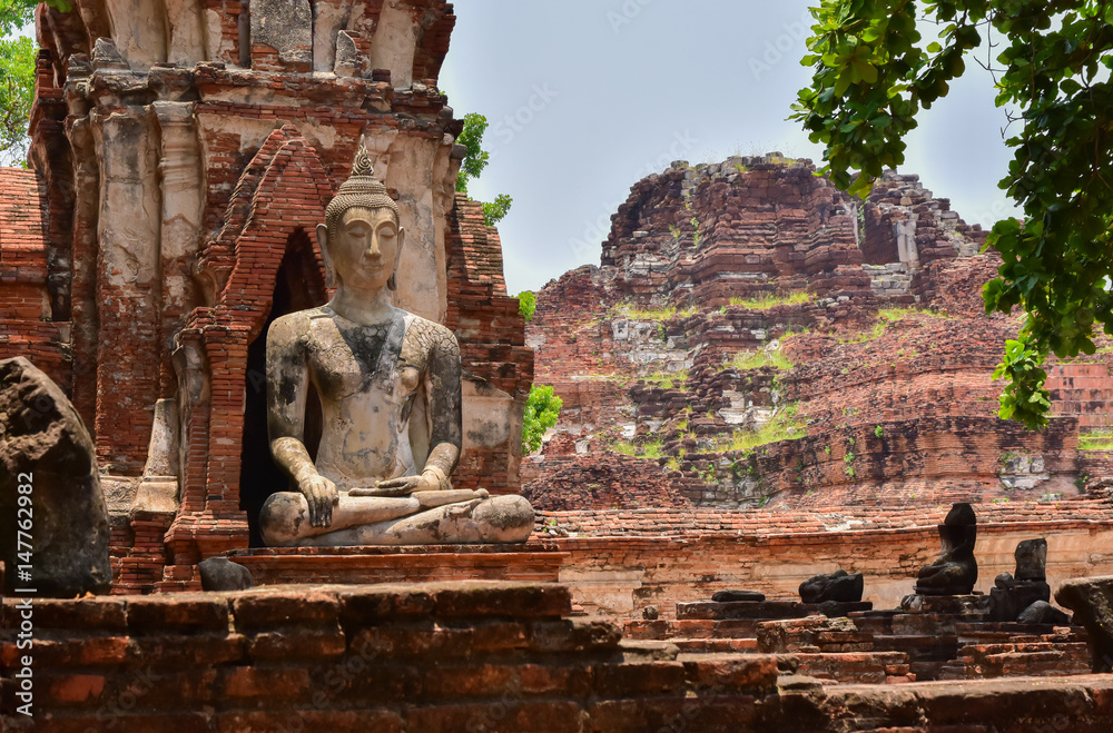 Ruins of stupa and statue of Buddha in Wat Mahathat, the ancient Thai temple in Ayutthaya Historical Park. Was built in 1374
