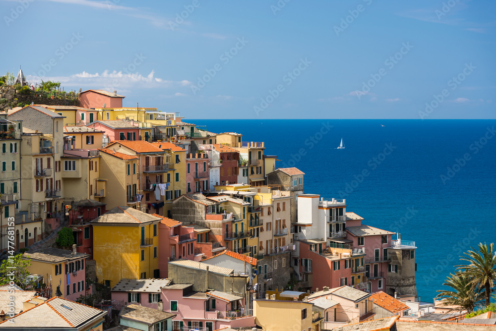 Color full Cinque Terre Manarola view with sailboats in sunny summer day in Italy