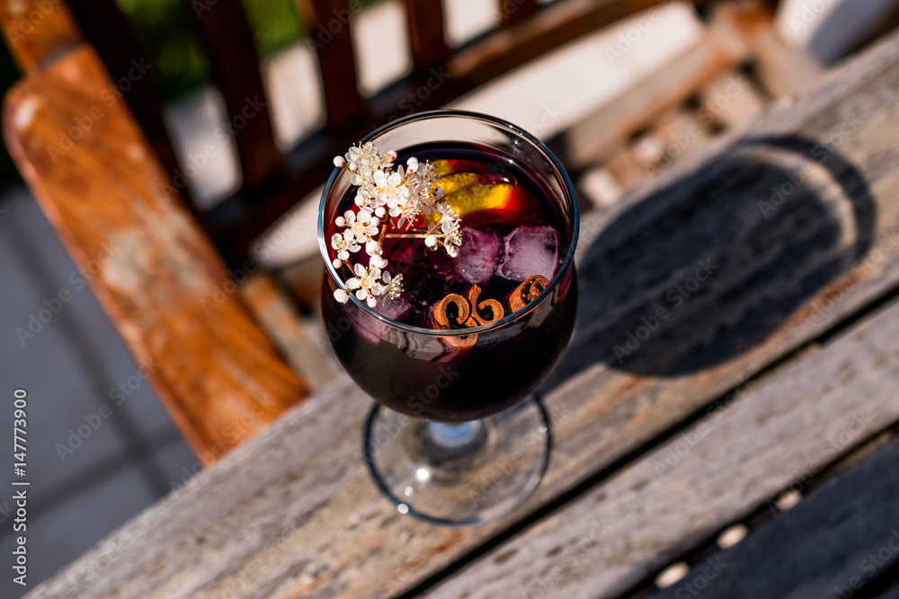 Sangria Cocktail in wine glass with lemon, cinnamon, fruits and ice. Sangria Cocktail in wine glass with lemon, cinnamon, fruits and ice.