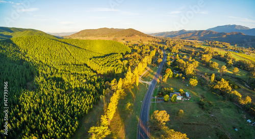 Great Alpine Road passing through Australian countryside at sunset - aerial landscape. Victoria, Australia photo