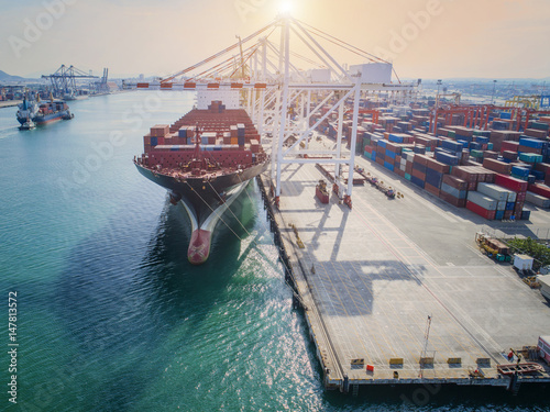 container ship vessel loading and discharging operation of transhipment in international port in aerial view