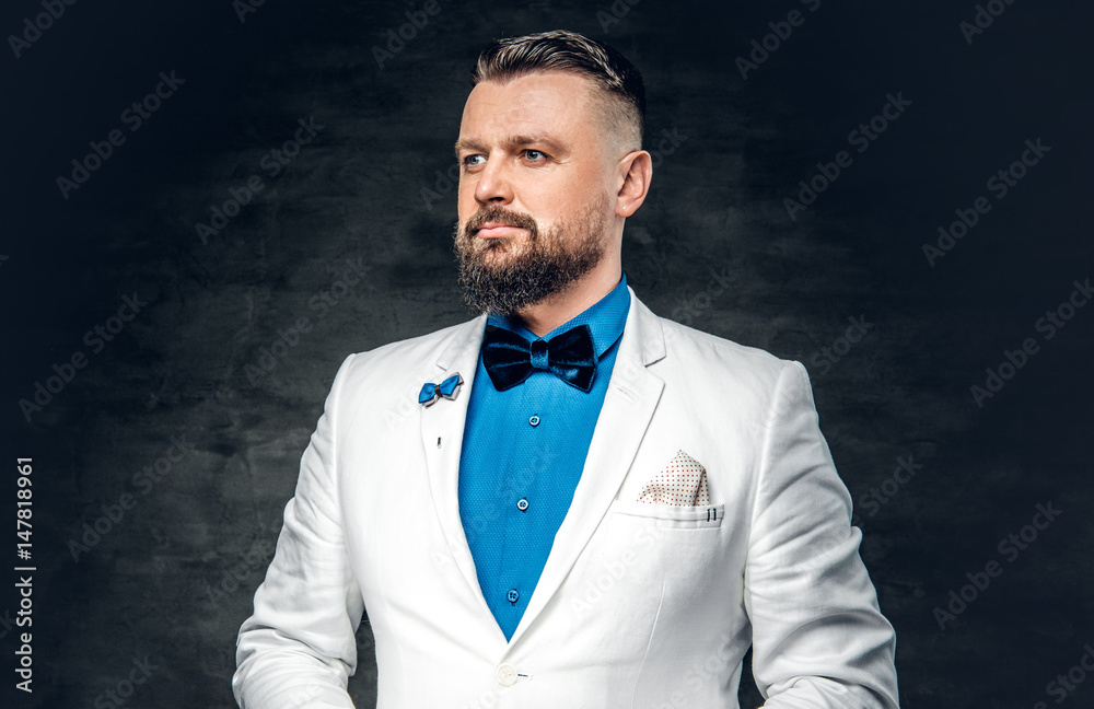 A man dressed in a blue shirt, white jacket and a bow tie. A man dressed in a blue shirt, white jacket and a bow tie.