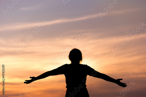 Silhouette young woman relaxing in  sunset sky outdoor.