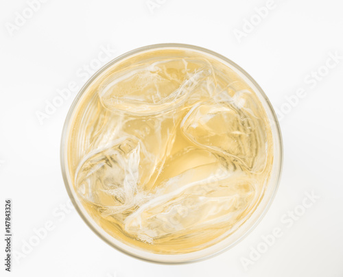 glass of soda with ice blocks isolated on yellow background, top view