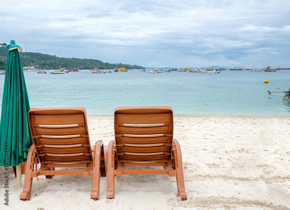 Two beach chairs on white sand