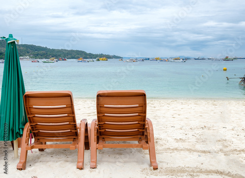 Two beach chairs on white sand