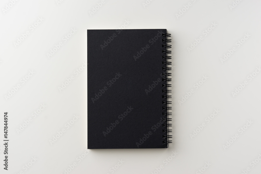 Business concept - Top view of spiral blank notebook on white background desk for mockup Business concept - Top view of spiral blank notebook on white background desk for mockup