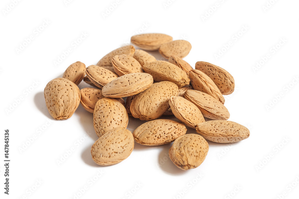 A lot of almond nuts in the shell isolated on white background, selective focus A lot of almond nuts in the shell isolated on white background, selective focus