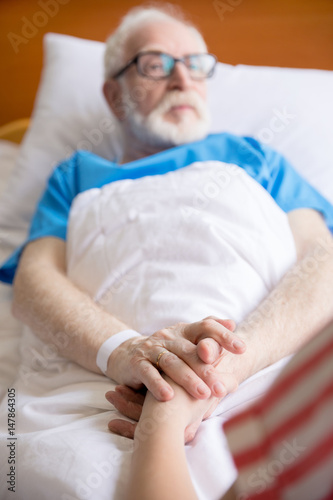senior patient holding hands