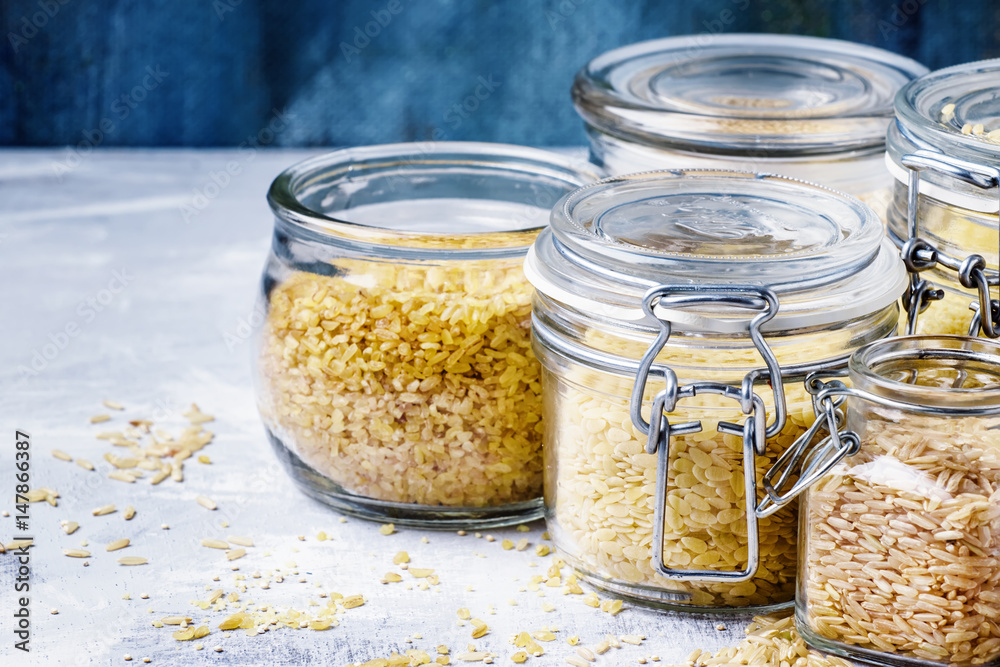 Assorted cereals in glass jars: kinoa, bulgur, couscous, orzo, brown rice, selective focus Assorted cereals in glass jars: kinoa, bulgur, couscous, orzo, brown rice, selective focus