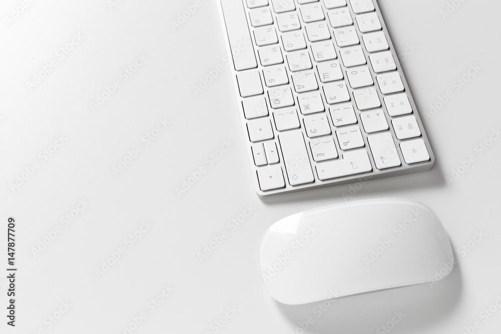 Computer keyboard and mouse on top of white desktop Computer keyboard and mouse on top of white desktop