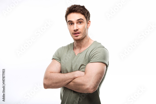 handsome man standing with crossed arms and looking at camera isolated on white