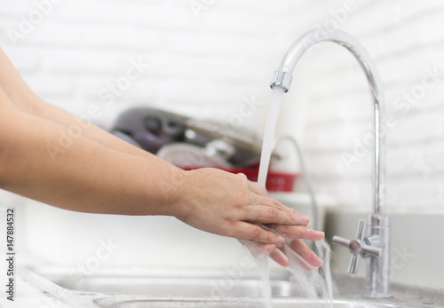 woman washing hand in kitchen sink for good Hygiene.