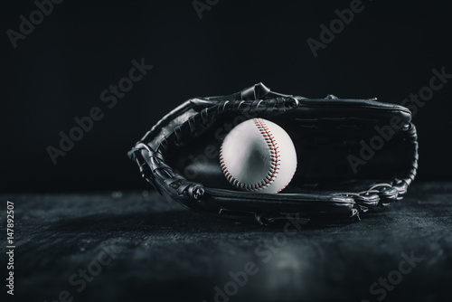 Photography Close-up view of leather baseball glove and ball on black