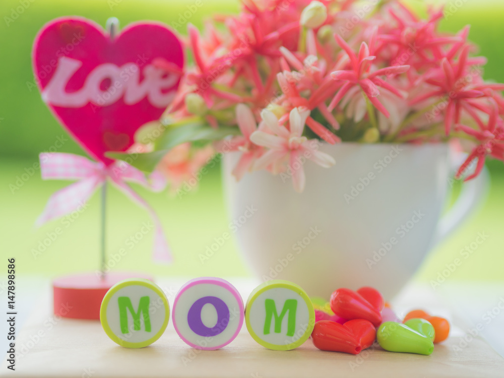 mother's day concept.  LOVE MOM alphabet with colorful heart and flower on background