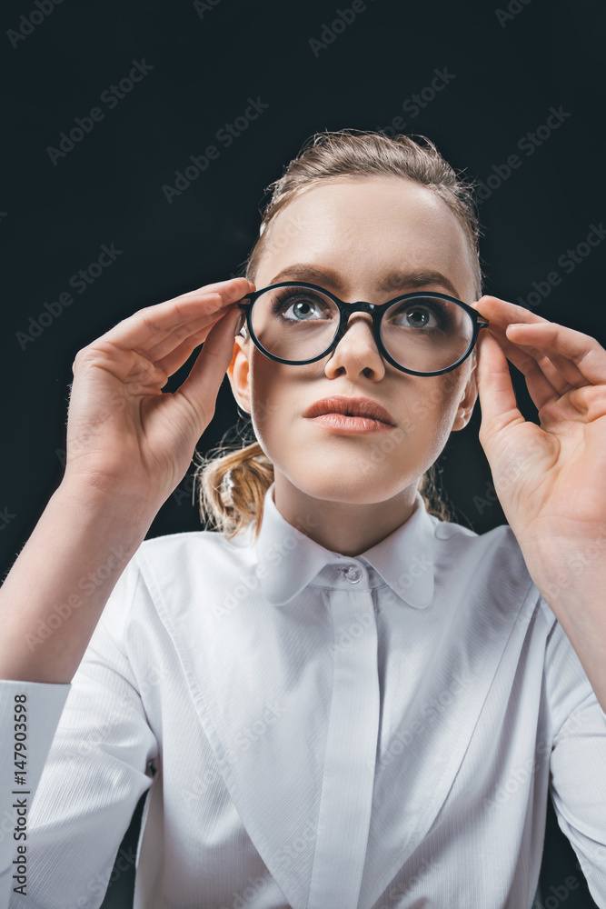 young woman in eyeglasses looking away