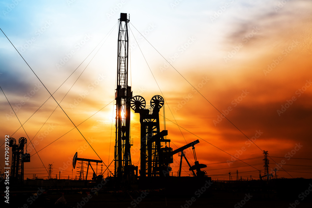 In the evening, the silhouette of oilfield derrick In the evening, the silhouette of oilfield derrick