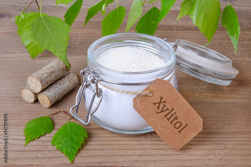 sugar substitute xylitol, a glass jar with birch sugar, liefs and wood