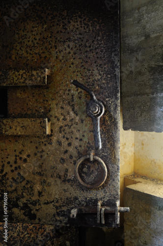 Rusty old heavy metal door in an underground bunker at Point du Hoc France © el-bee