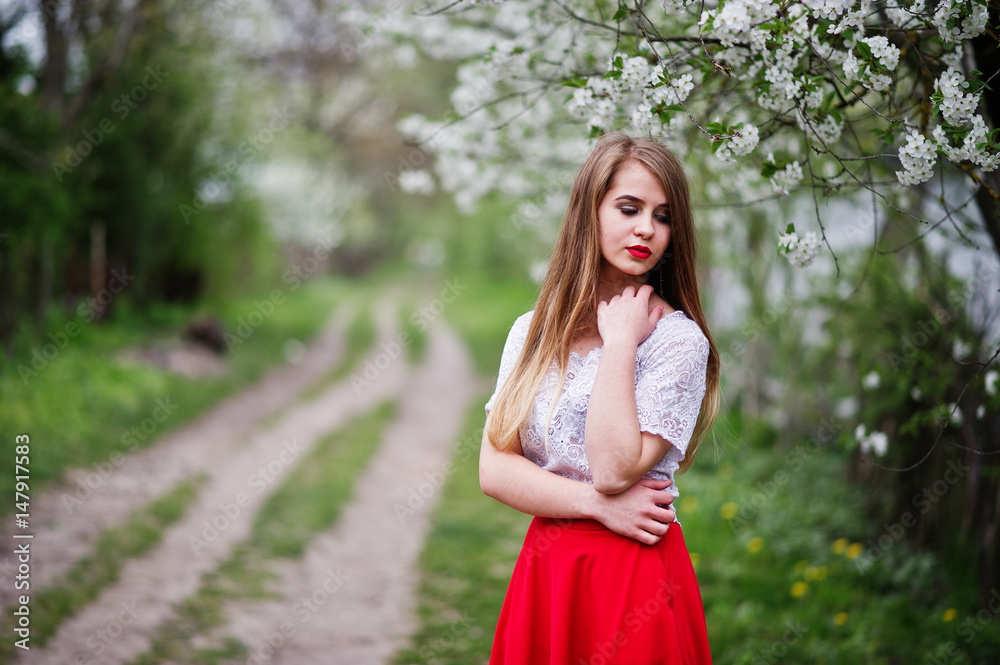 Portrait of beautiful girl with red lips at spring blossom garden, wear on red dress and white blouse. Portrait of beautiful girl with red lips at spring blossom garden, wear on red dress and white blouse.